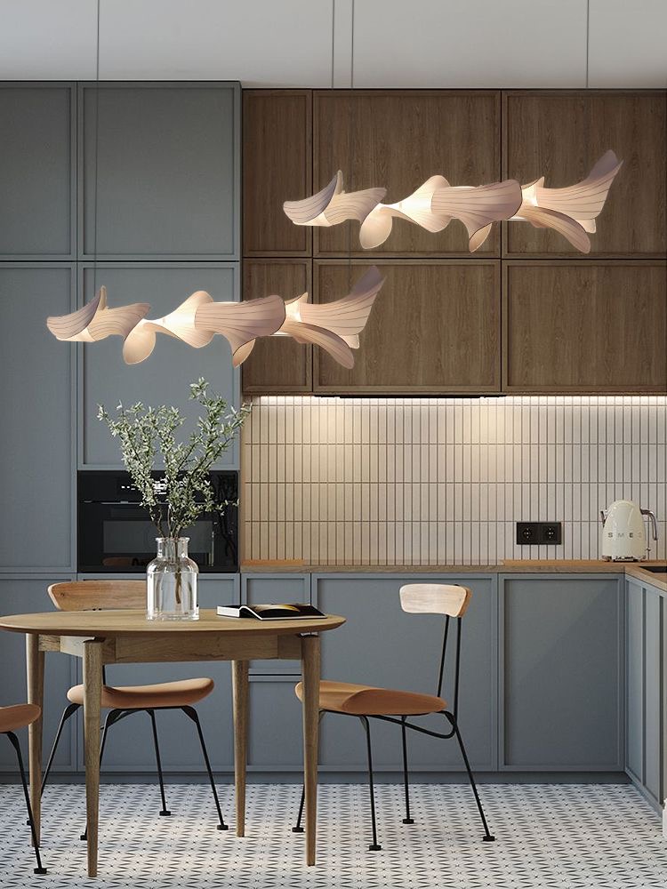 Kitchen in muted blue with sculptural pendant lights above a round oak dining table